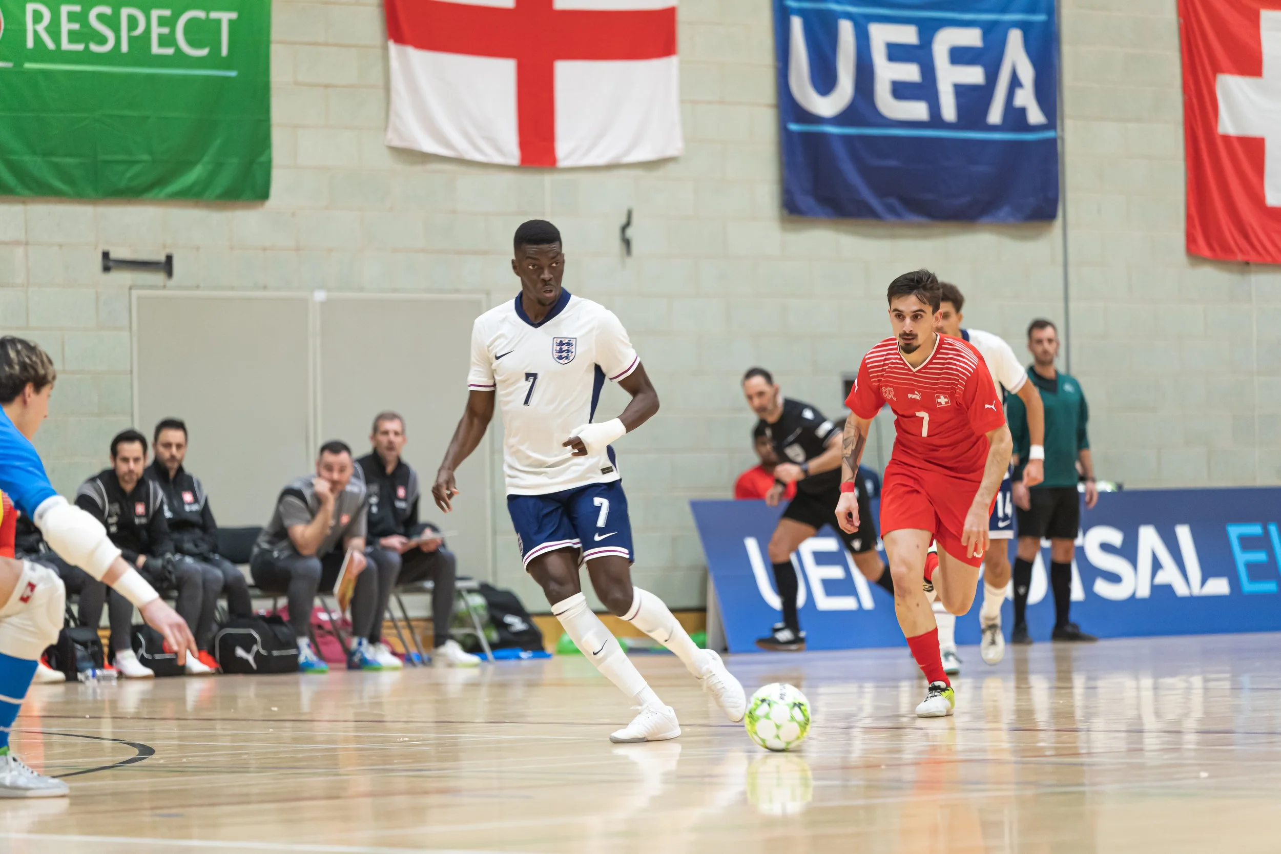 England futsal player controlling the ball during an indoor match against Switzerland
